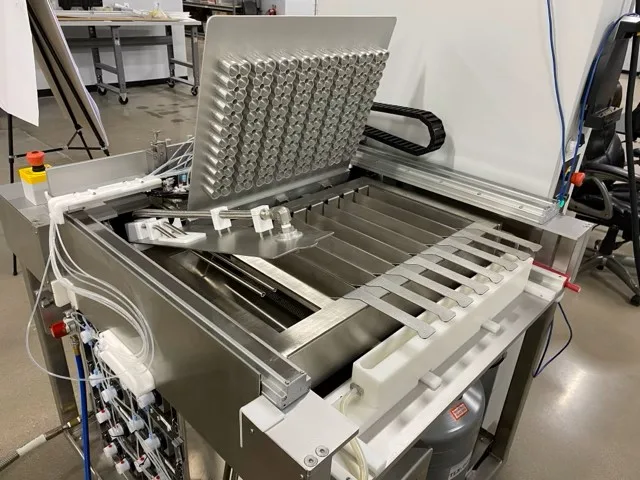 Eight-chamber frozen pellet machine with its dispensing nozzle array exposed