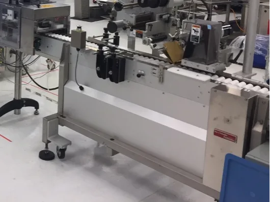 Intermittent-motion labeling machine applying labels to containers on a production line
