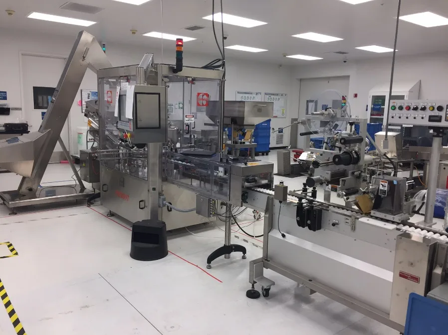 Monoblock tube filling and capping machine with an inline labeling and print inspection section downstream on a medical device production floor