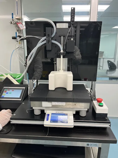 Benchtop small-fill station close-up with dispense head, product nest and balance